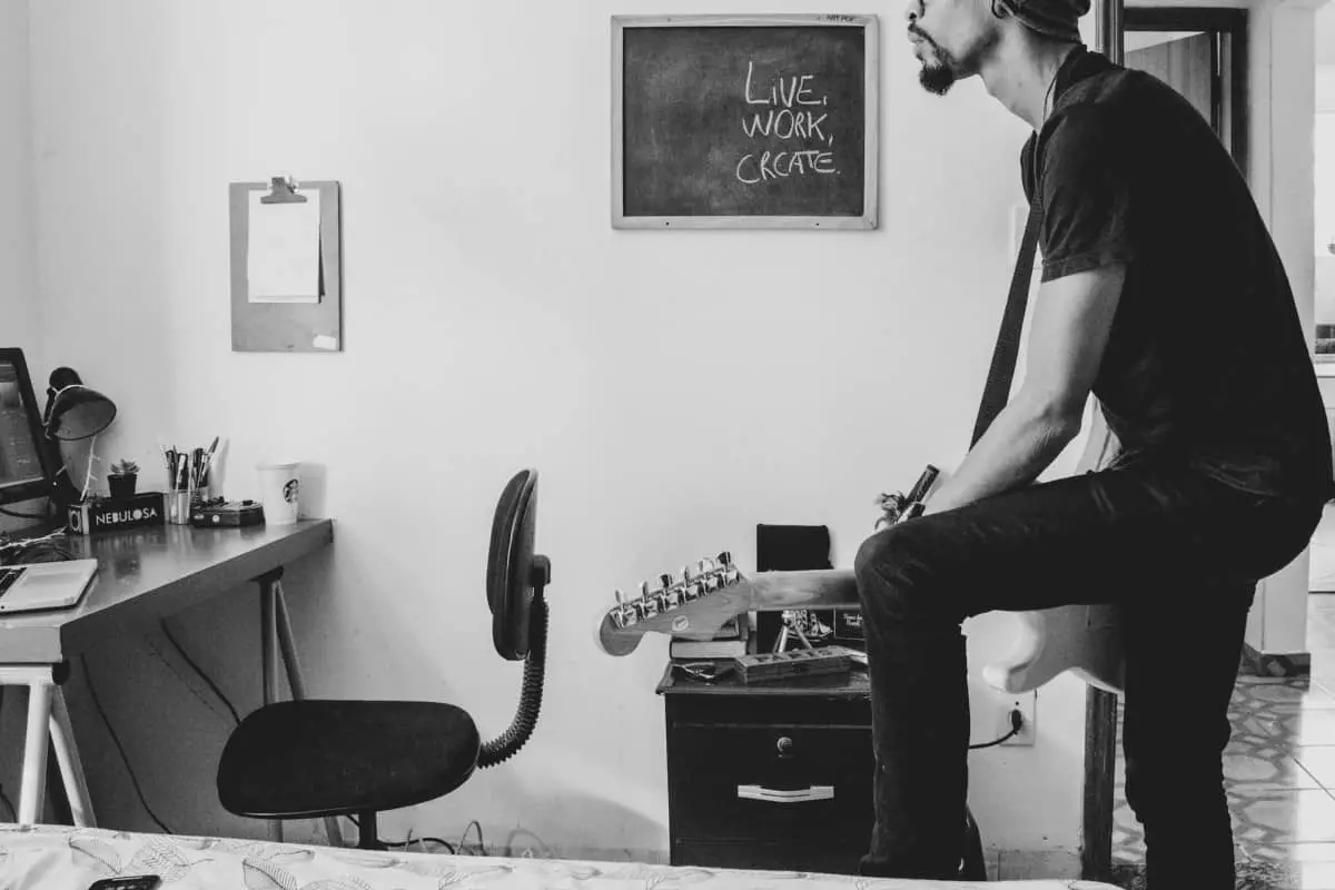 best way to learn guitar at home - man playing electric guitar at home