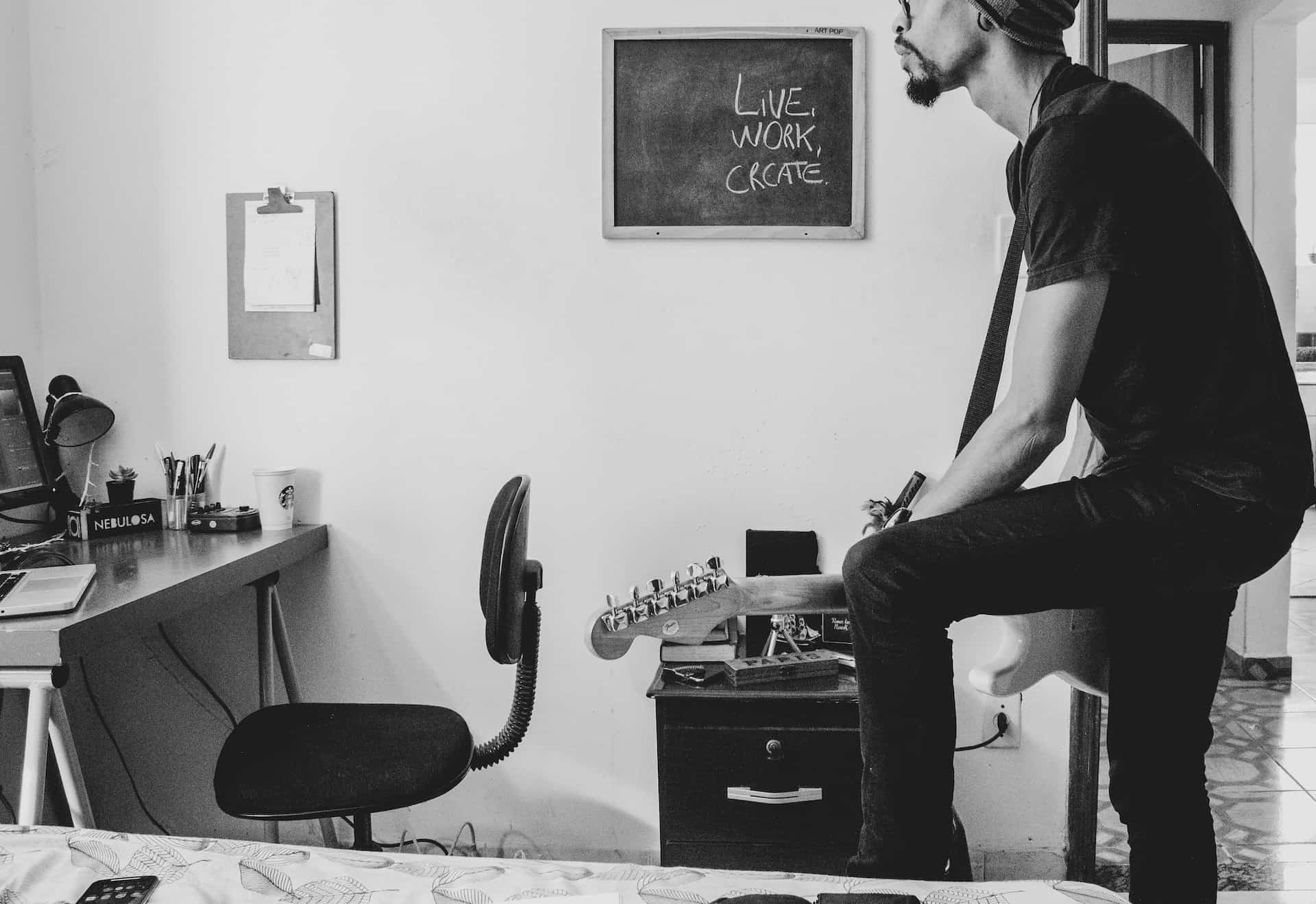 best way to learn guitar at home - man playing electric guitar at home