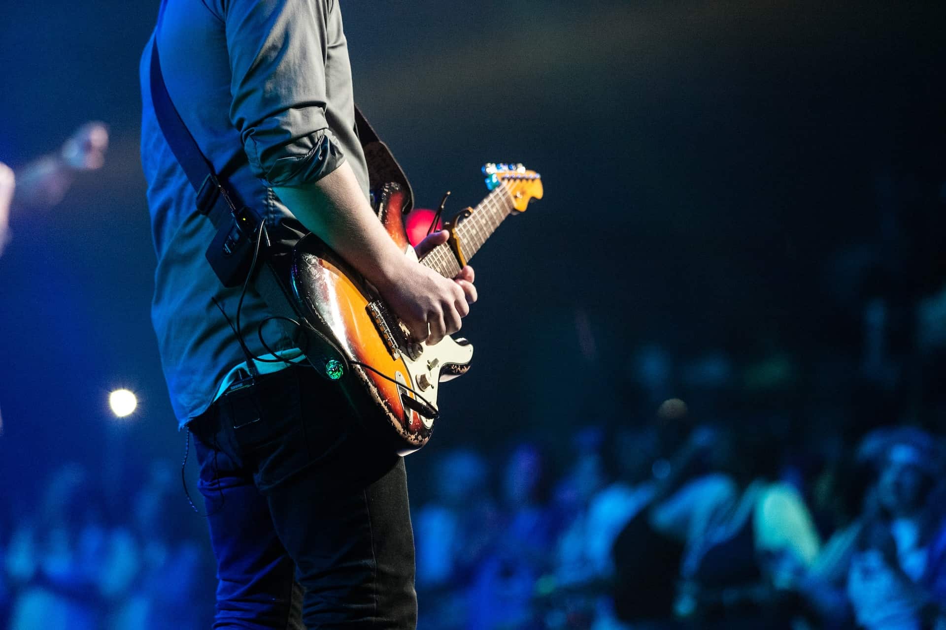 best way to learn songs on guitar - man playing electric guitar live on stage