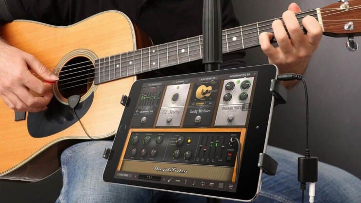 how to connect guitar amp to computer - man playing guitar with amp on tablet