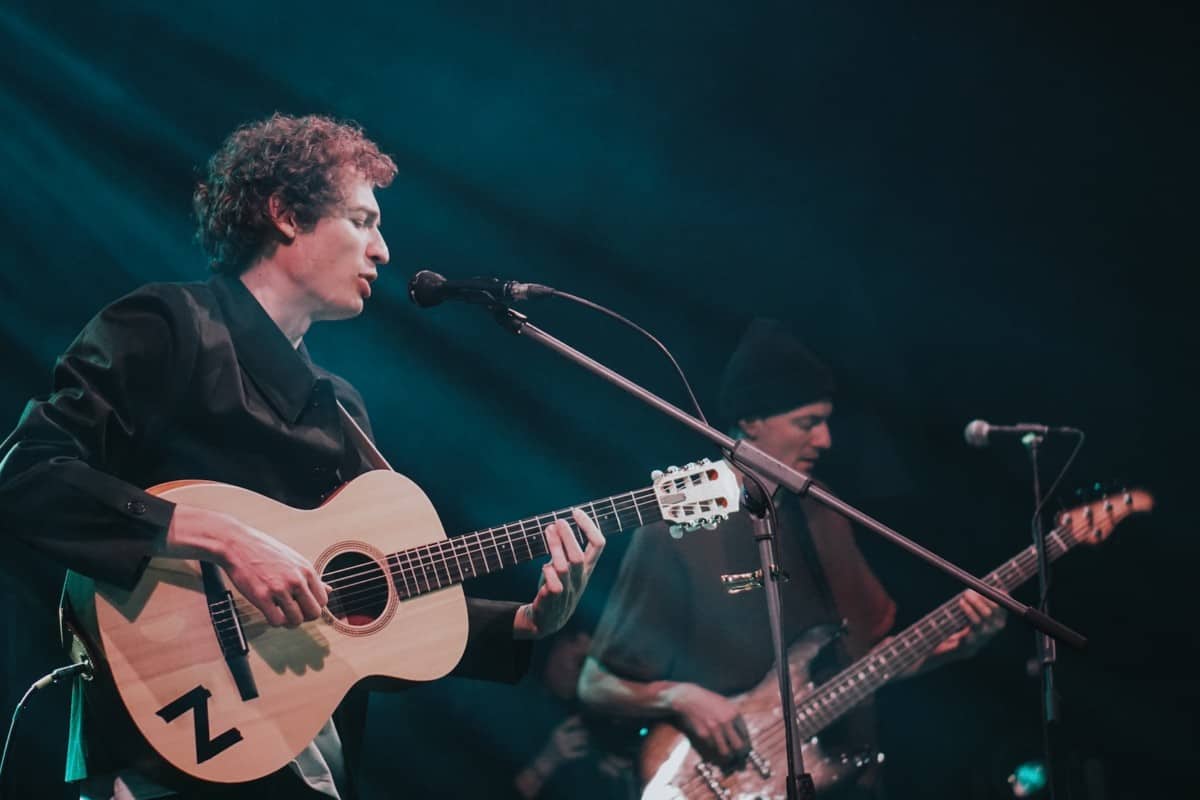 how to learn power chords on acoustic guitar - man playing power chord on acoustic guitar on stage