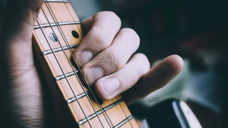 hurt fingers of man with calluses while playing guitar