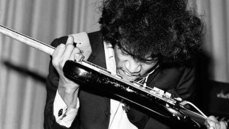 jimi hendrix holding guitar