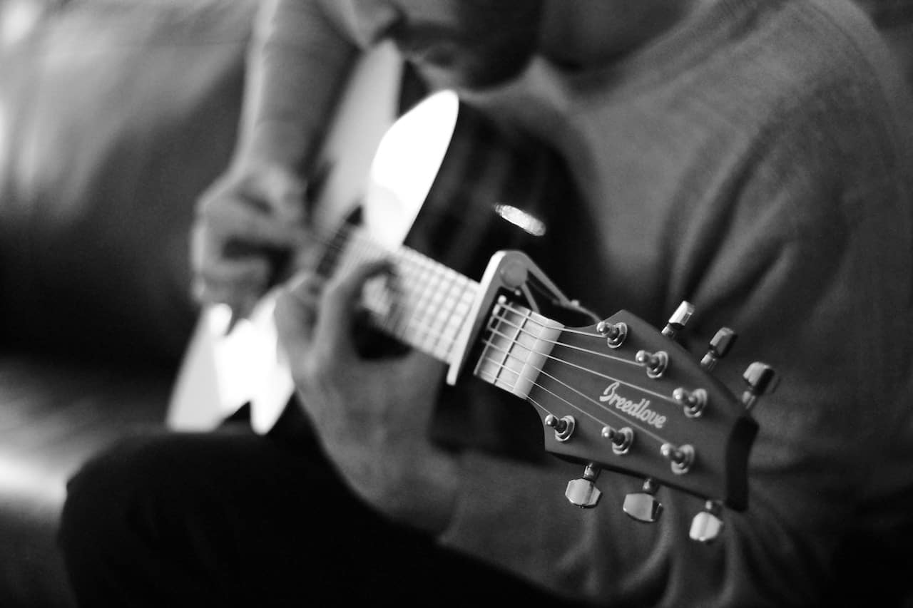 learn how to strum an acoustic guitar - man playing acoustic guitar