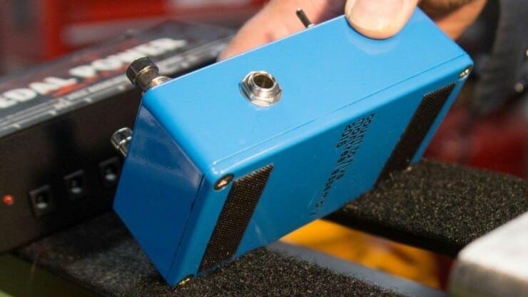 man attaching guitar pedals in pedalboard velcro