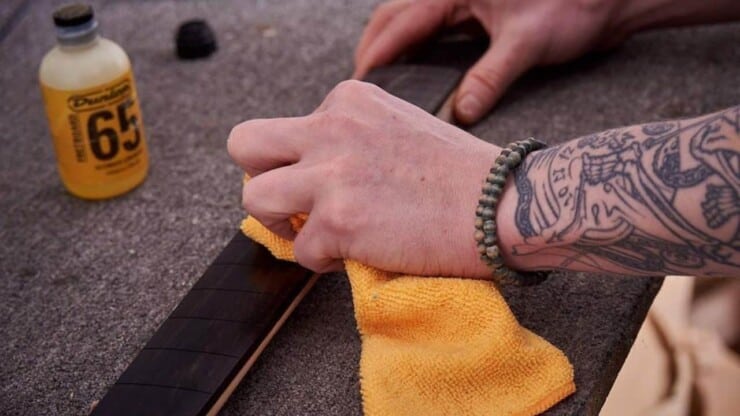 man cleaning guitar