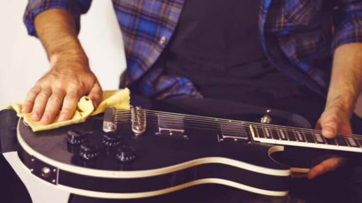 man wiping guitar