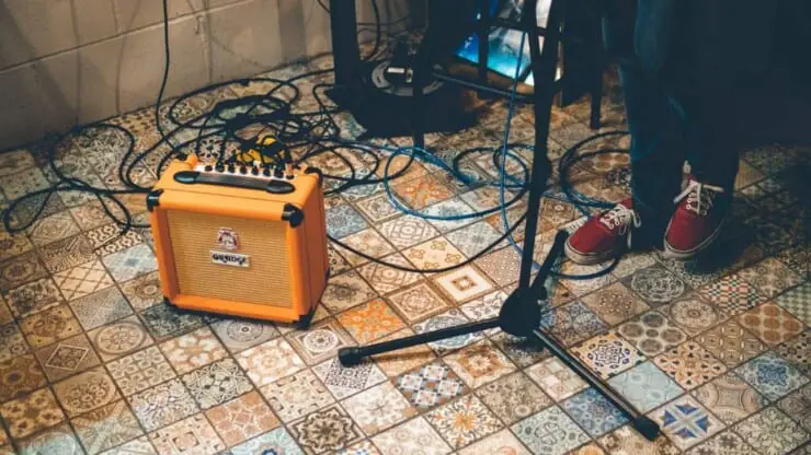 what is a modeling guitar amp - guitarist playing electric guitar with orange amp on the floor