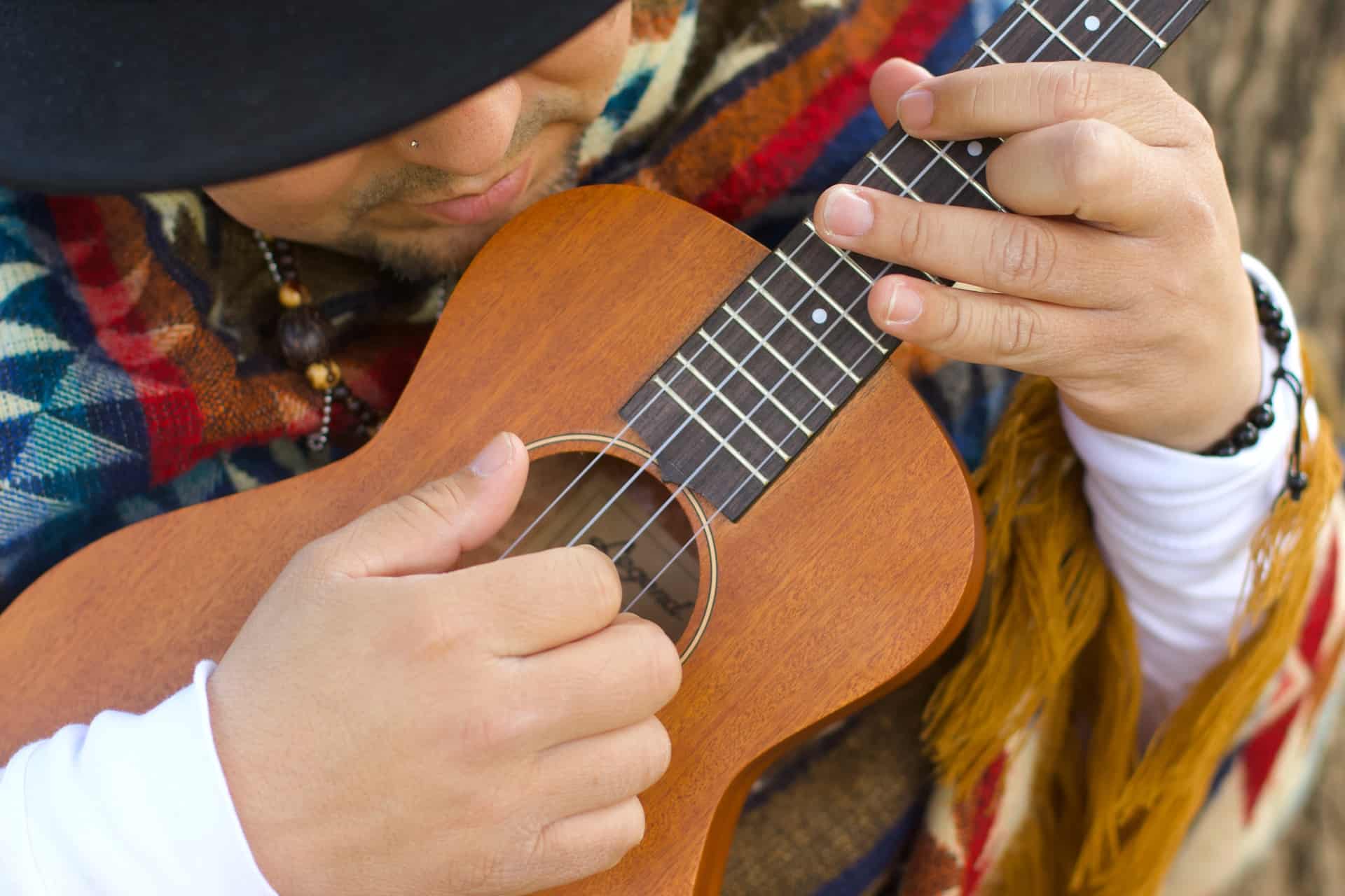which is easier to learn guitar or ukulele - man playing ukulele